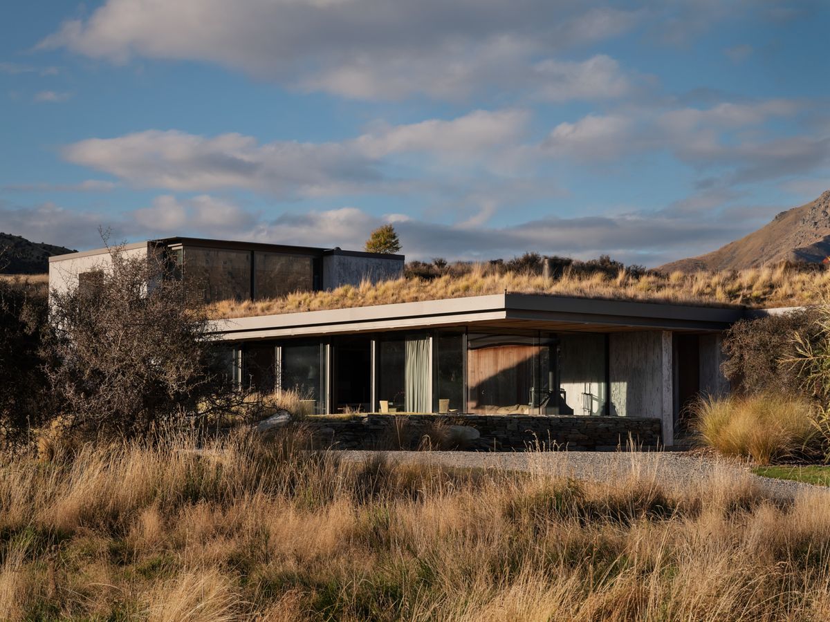 The lodge exterior with a grass-covered roof among Patagonian grasses.